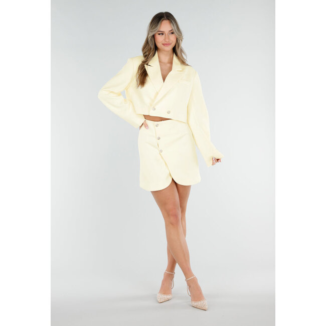 Buttergelber Minirock mit Überwurf und goldfarbenen Knöpfen auf der Vorderseite