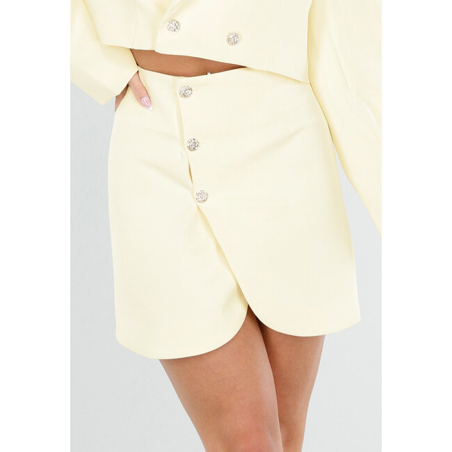 Buttergelber Minirock mit Überwurf und goldfarbenen Knöpfen auf der Vorderseite