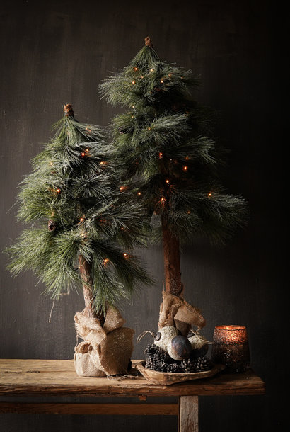 Artificial Christmas tree on wooden tree trunk