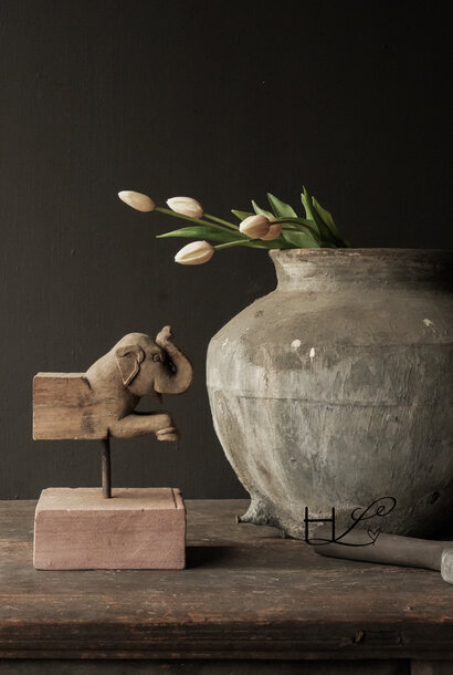 Unique old wooden elephant on a stone pedestal