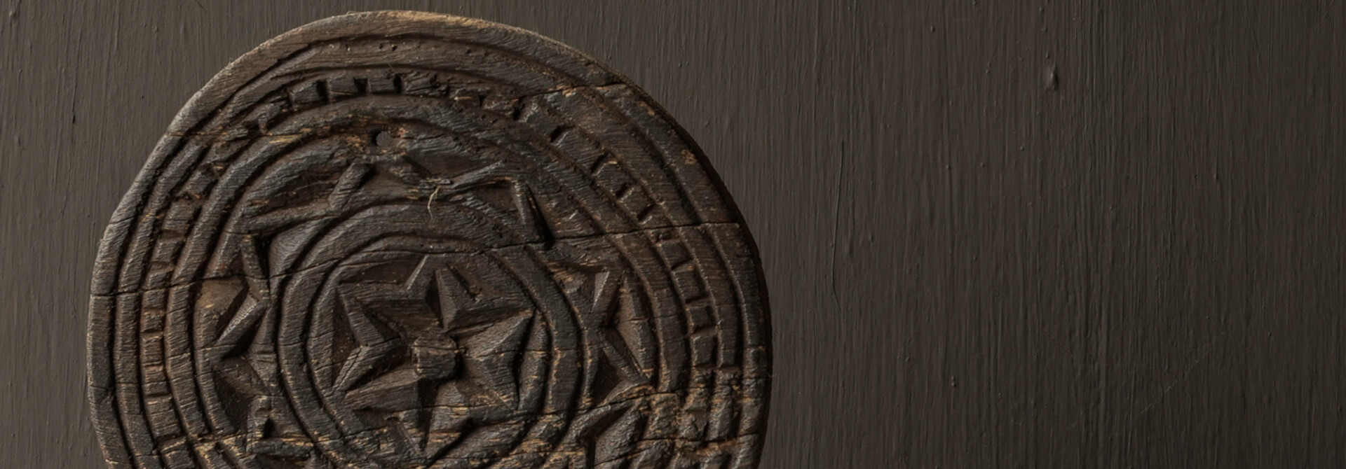 Round wooden ornament on an iron base