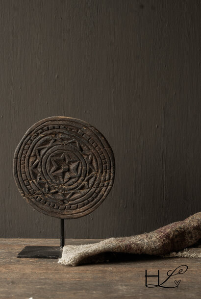 Round wooden ornament on an iron base