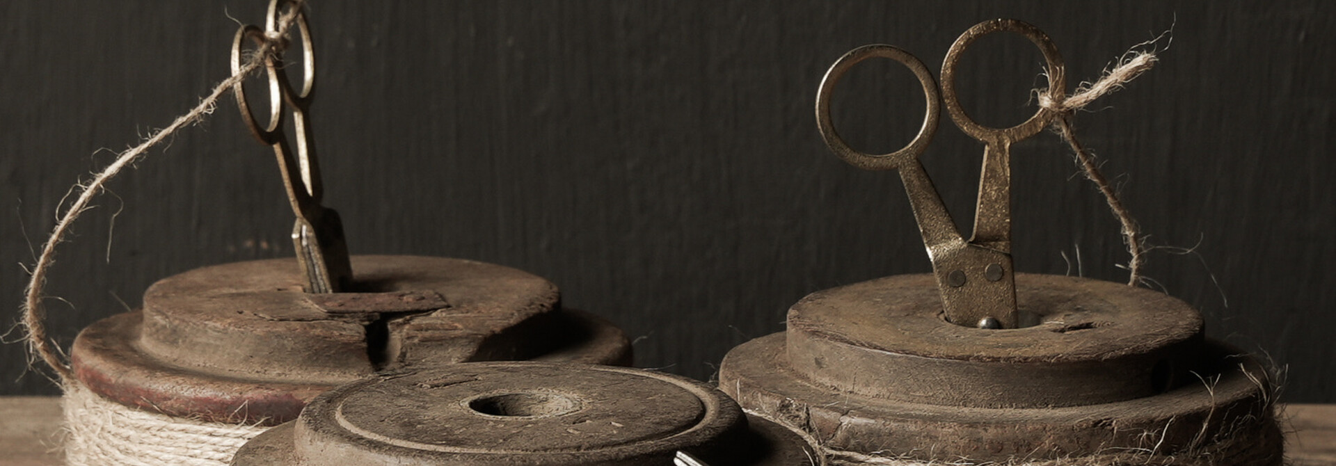 Old wooden spool with rope and scissors