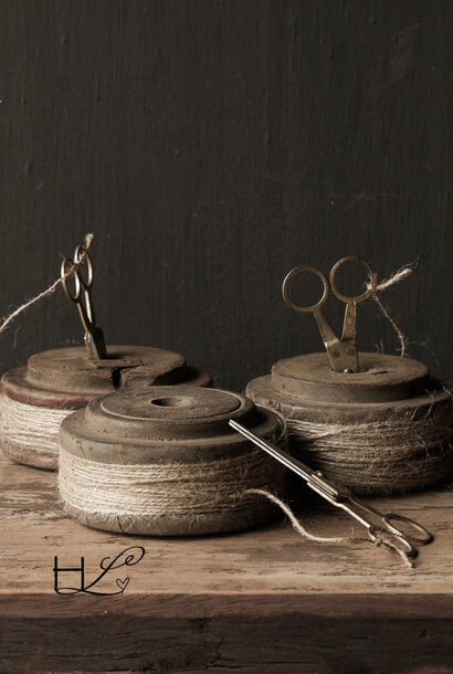 Old wooden spool with rope and scissors