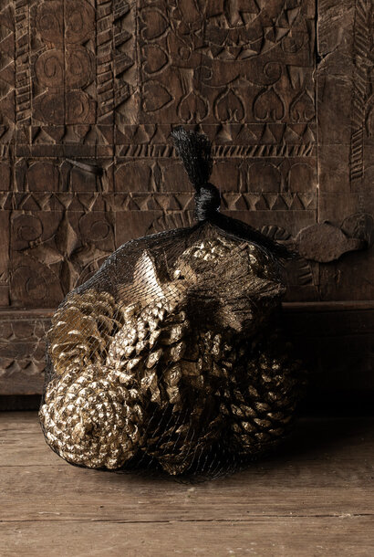 Netz aus Tannenzapfen mit drei goldenen Sternen