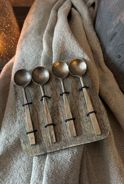 Geschenkset mit Löffeln, Gabeln oder Käsebesteck auf einem Holzteller