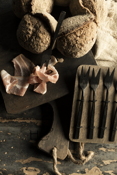 Gift set of spoons, forks or cheese cutlery on a wooden plate Black