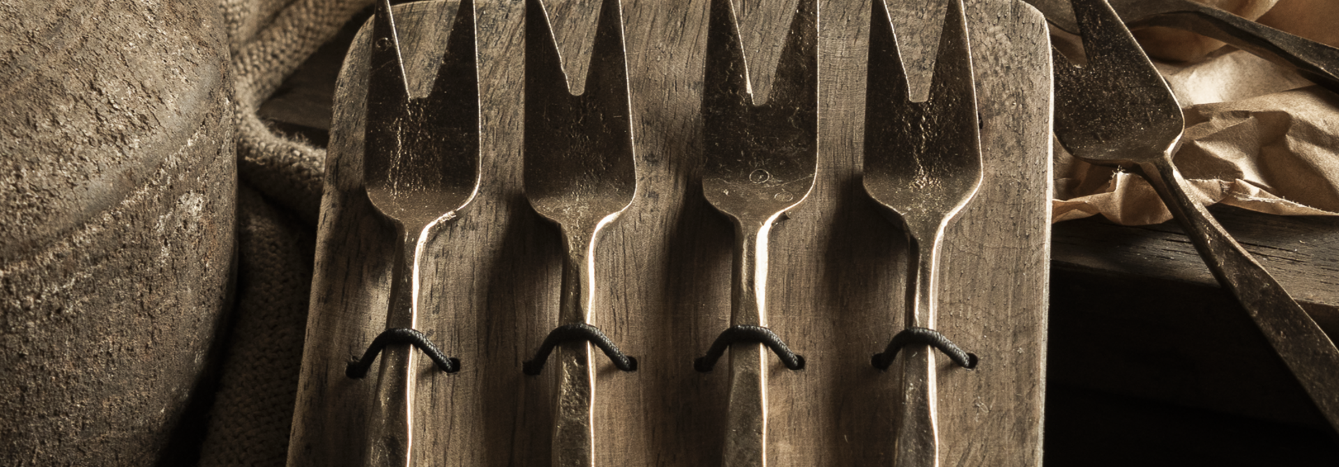 Gift set of spoons, forks or cheese cutlery on a wooden plate