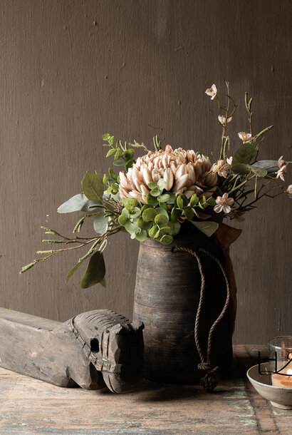 Verwitterter Holzkrug mit künstlichem Blumenstrauß