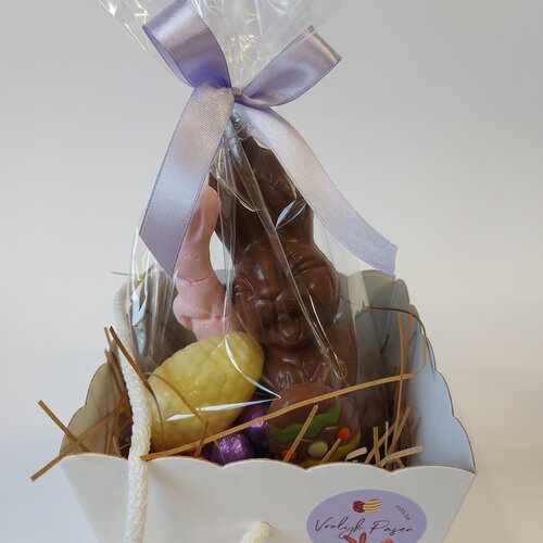 Draagmand gevuld met lachhaasje en assorti eitjes.