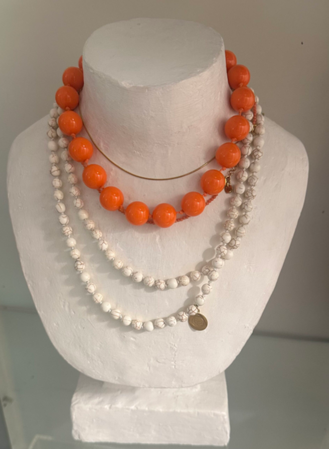 Ellen beekmans korte ketting  met grote ronde kralen fel oranje