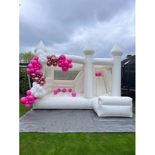 Ballondecoratie bij een springkasteel in roze tinten
