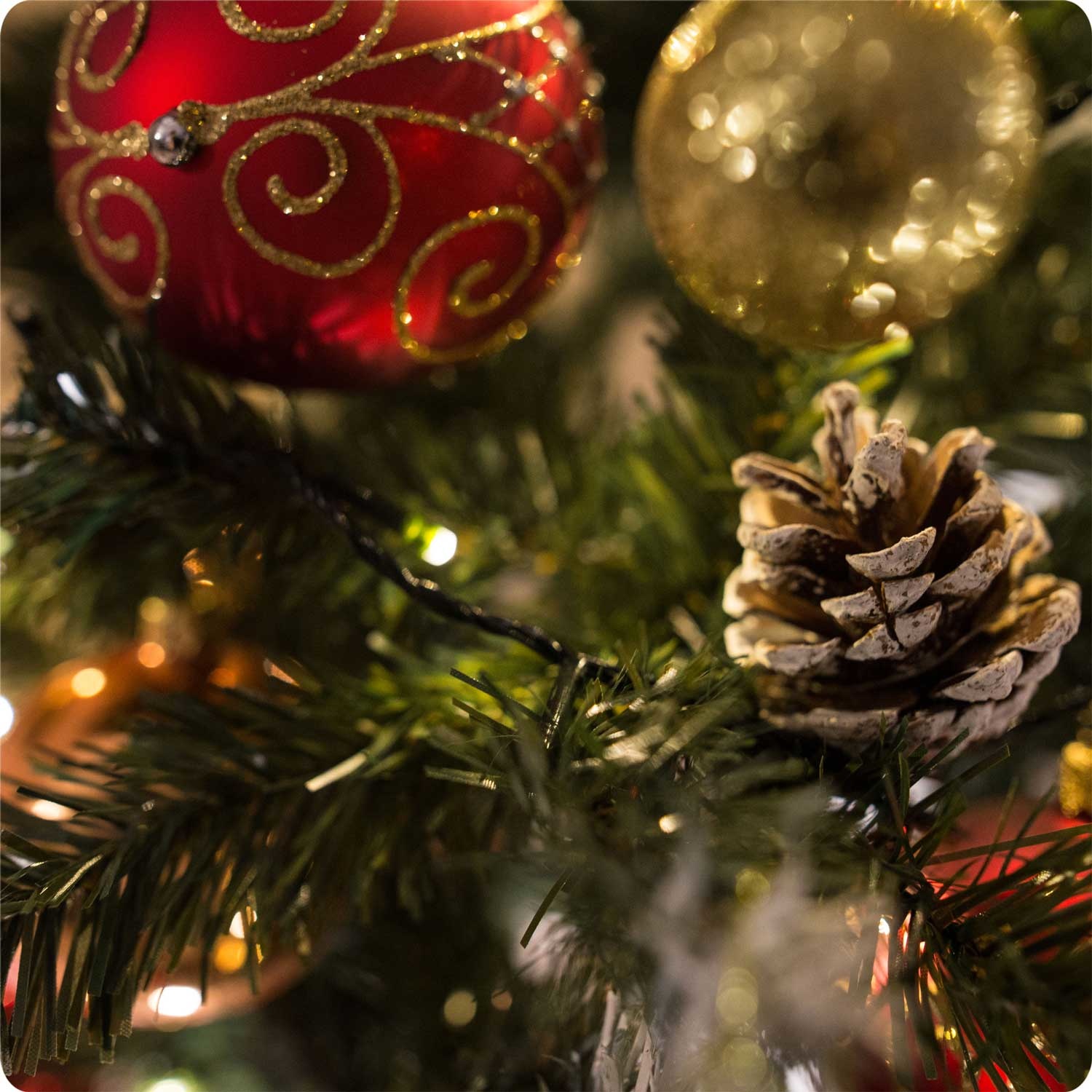 Kunstkerstboom - 180 cm - op houten stam - met Dennenappels