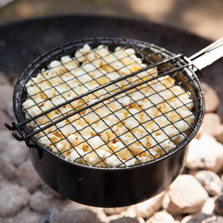 Bij Heldere Hemel Popcorn maken boven een vuurtje.