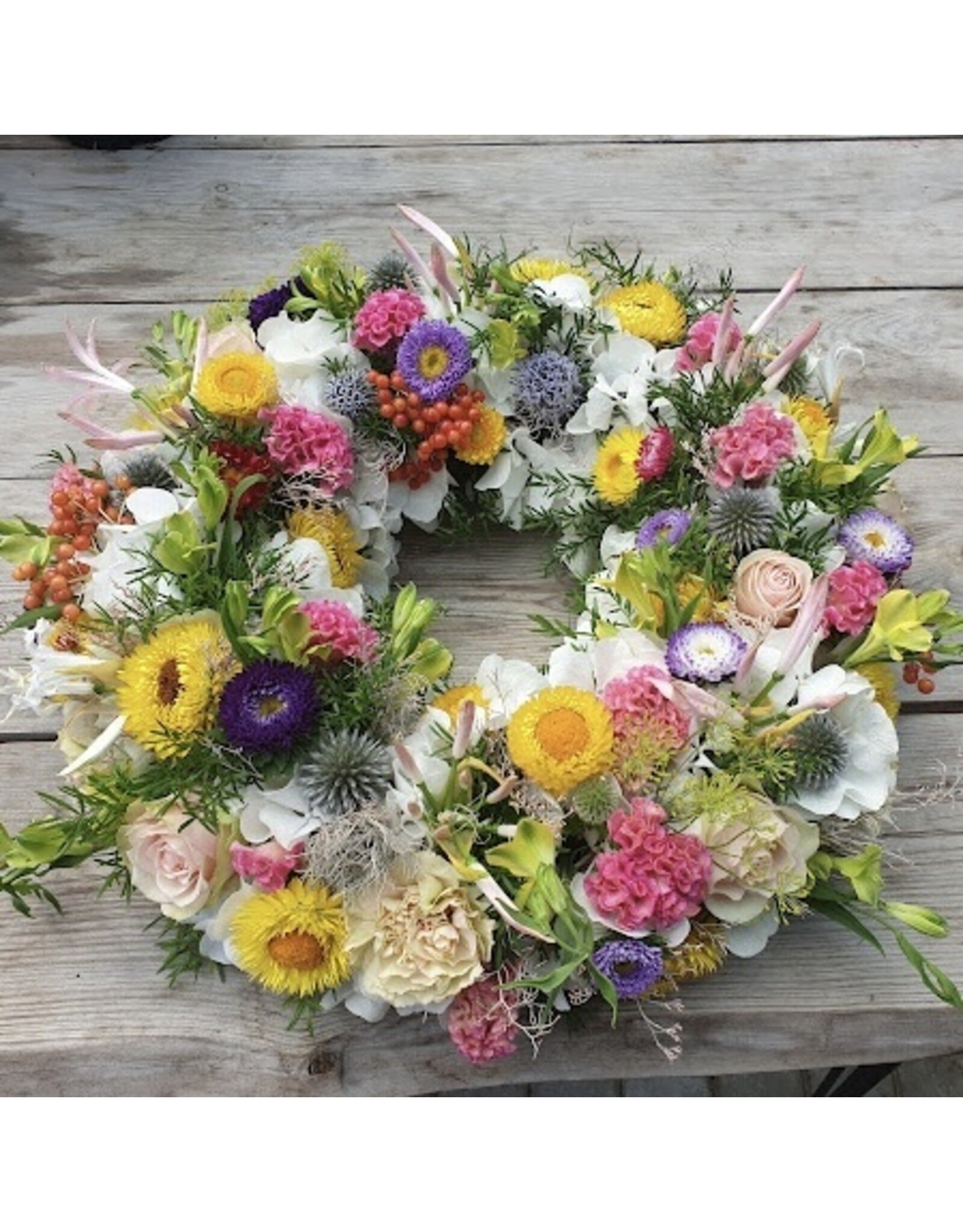 rouwkrans volledig uitgewerkt met veel bloemen in kleur naar keuze