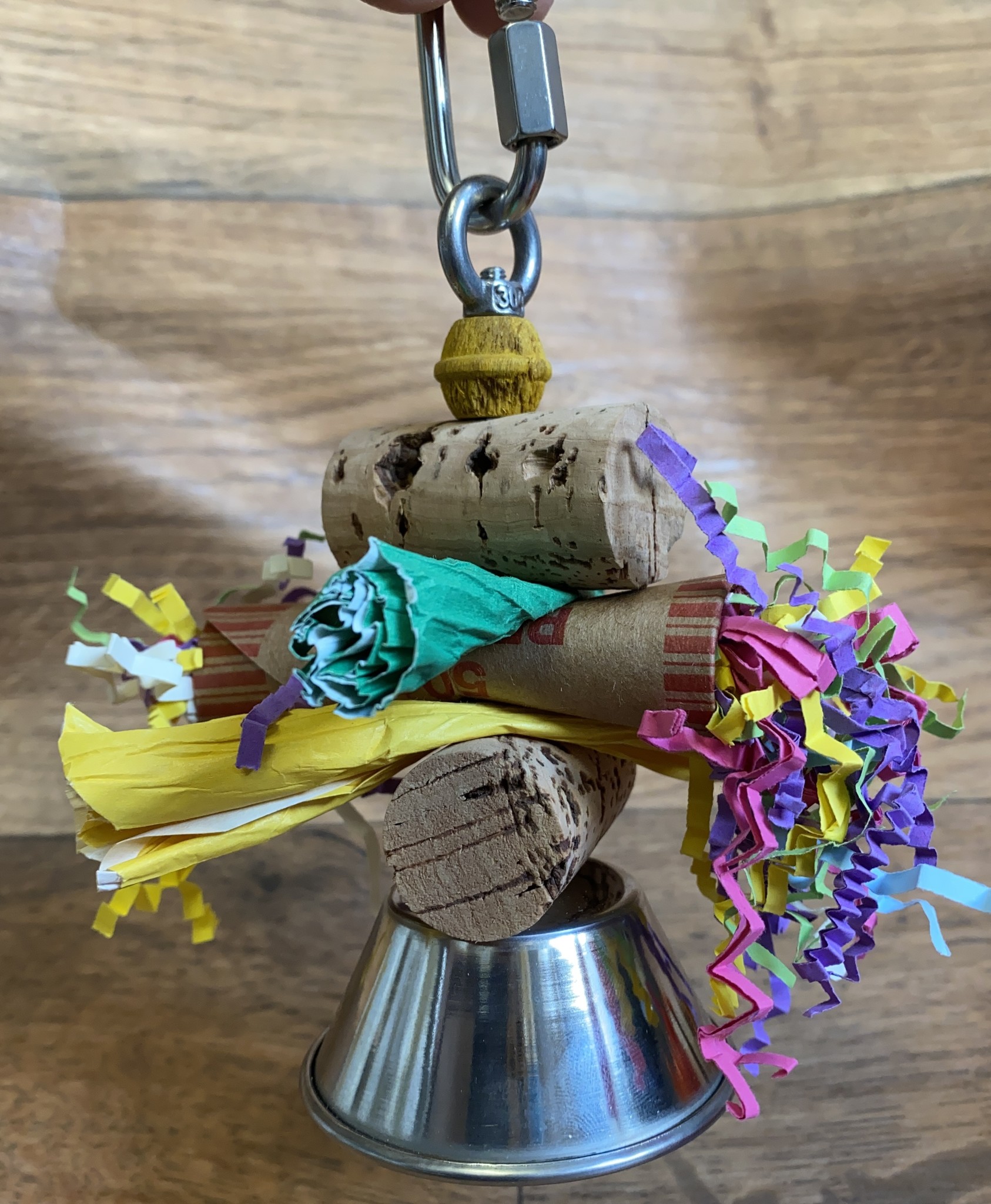 Parakeets gnawing bell paper/cork