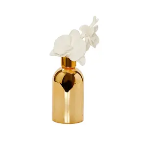 Diffuseur de bouteille en or avec bouchon de fleur blanche