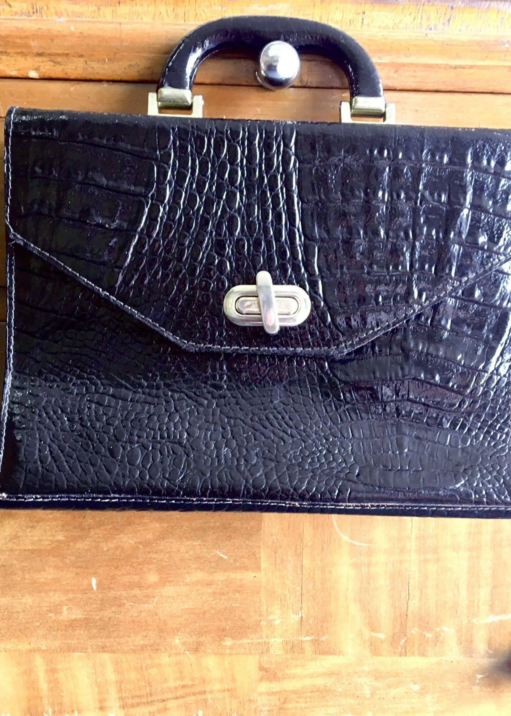 Black lacquered crocodile bag without shoulder strap with gold closure