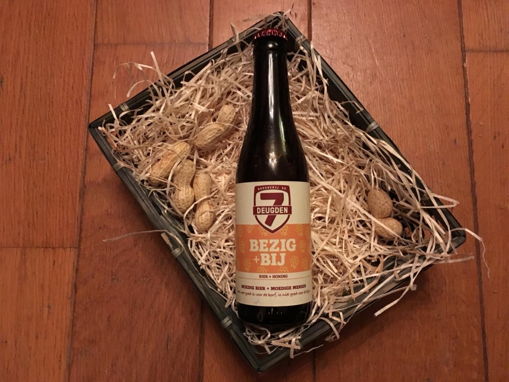 Bezig+Bij      Herkomst: Amsterdam, Nederland  Dat honing bij dit bier centraal staat is niet heel verrassend. Het bier heeft de kleur, geur en smaak van honing. De subtiele aanwezigheid van honing in de smaak wordt gecombineerd met een bittere smaak. In de geur ontdek je naast de honing ook ijzer. Het bier wordt afgesloten met een lichtzoete afdronk. Bezig + bij is afkomstig van brouwerij de 7 Deugden. Een brouwerij met een breed assortiment speciaalbieren, een proeverij naast de brouwerij en waar je terecht kunt voor rondleidingen en workshops. Het bier heeft een alcoholpercentage van: 6%. Advies serveertemperatuur: 6 tot 8 graden.