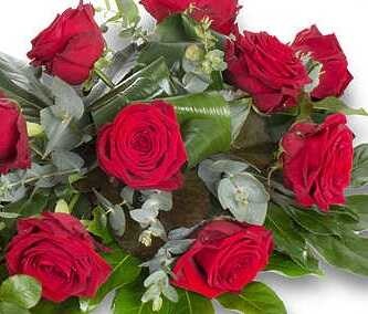 Rode rouwbloemen in een rouwbloemstuk