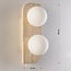 2-light wall lamp Artea in travertine (natural stone) with glass globes