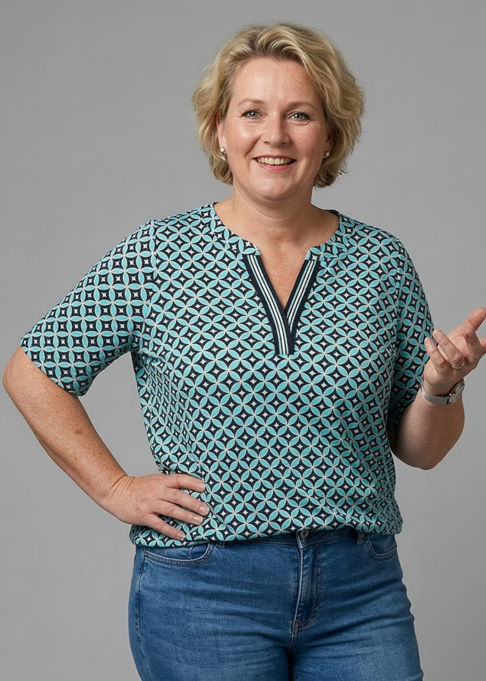 Via Appia Due 44: via appia 2612459  A photorealistic editorial studio portrait of a 50-year-old woman with a blond wavy short hair, smiling warmly. Body type: Authentic Dutch size 50 (plus size) with a full-figured, sturdy build. > Anatomical details: Realistically th