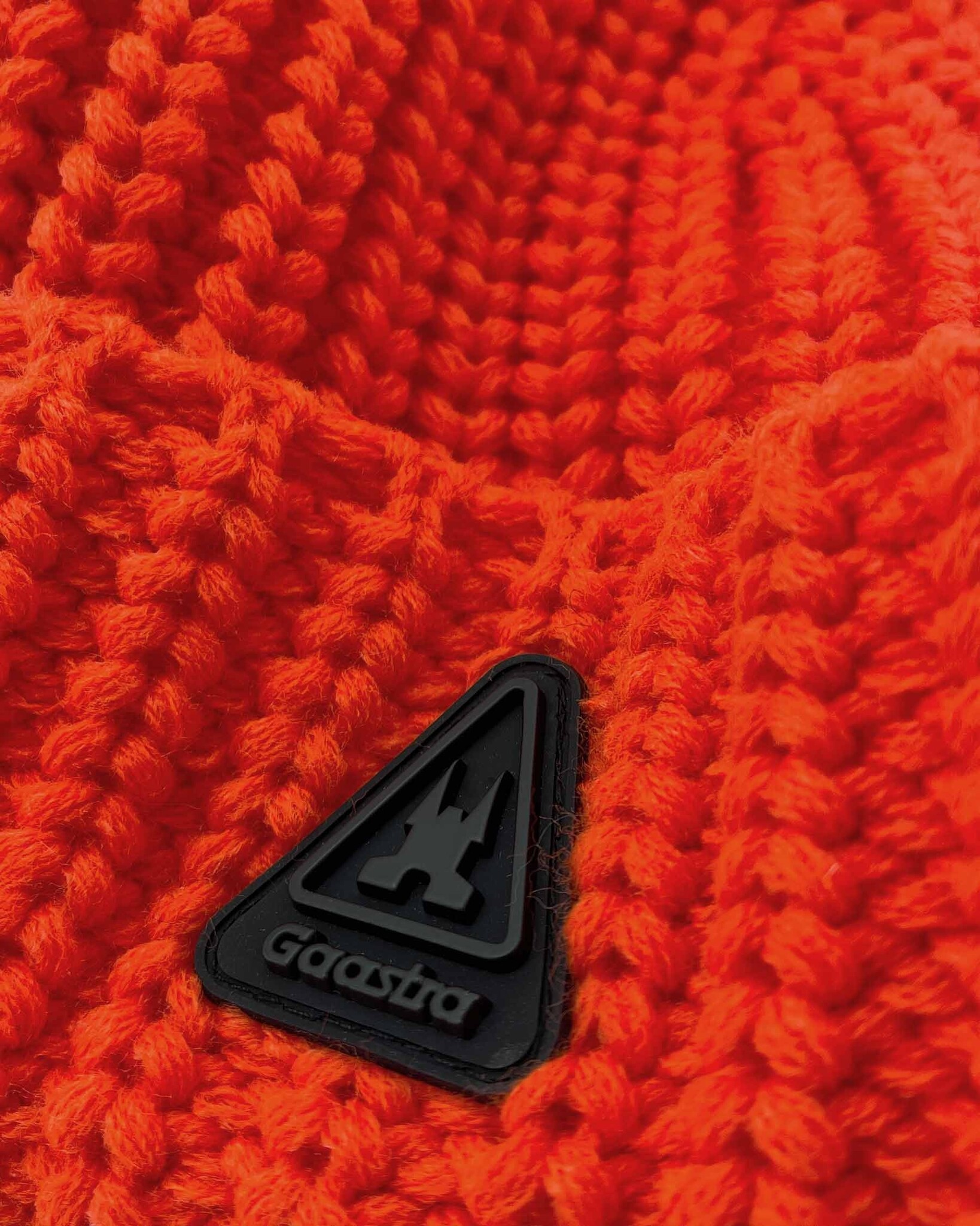 Heavy knitted pom pom beanie made from sustainable Polylana® fiber mix with trademark logo