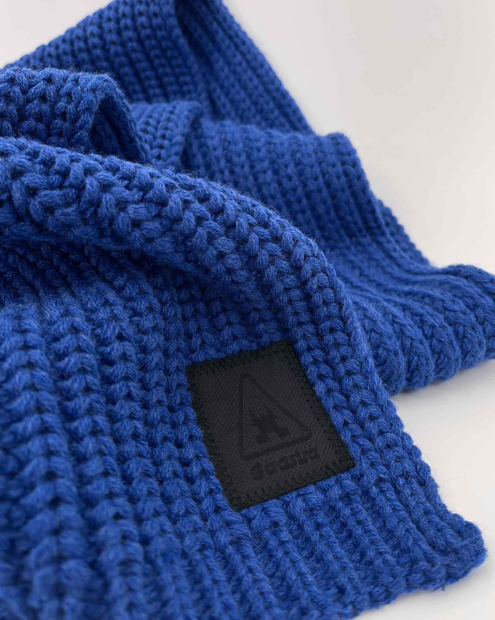 Heavy knitted yarn dyed scarf made from sustainable Polylana® fiber mix with trademark logo