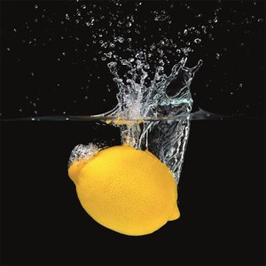 Fresh lemon falling into water