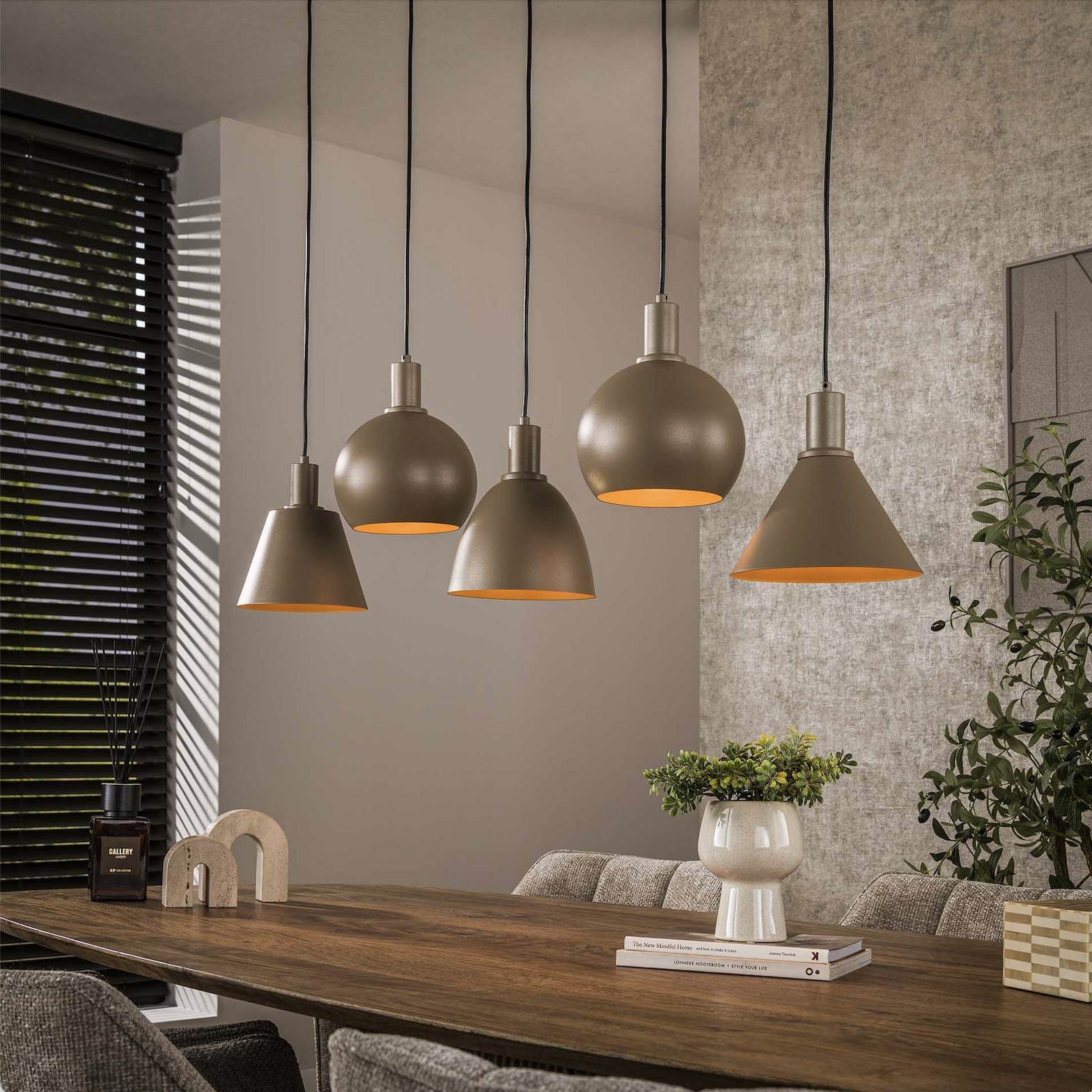 Beige metalen hanglamp boven houten eettafel, sfeervolle verlichting voor verbinding in huis.
