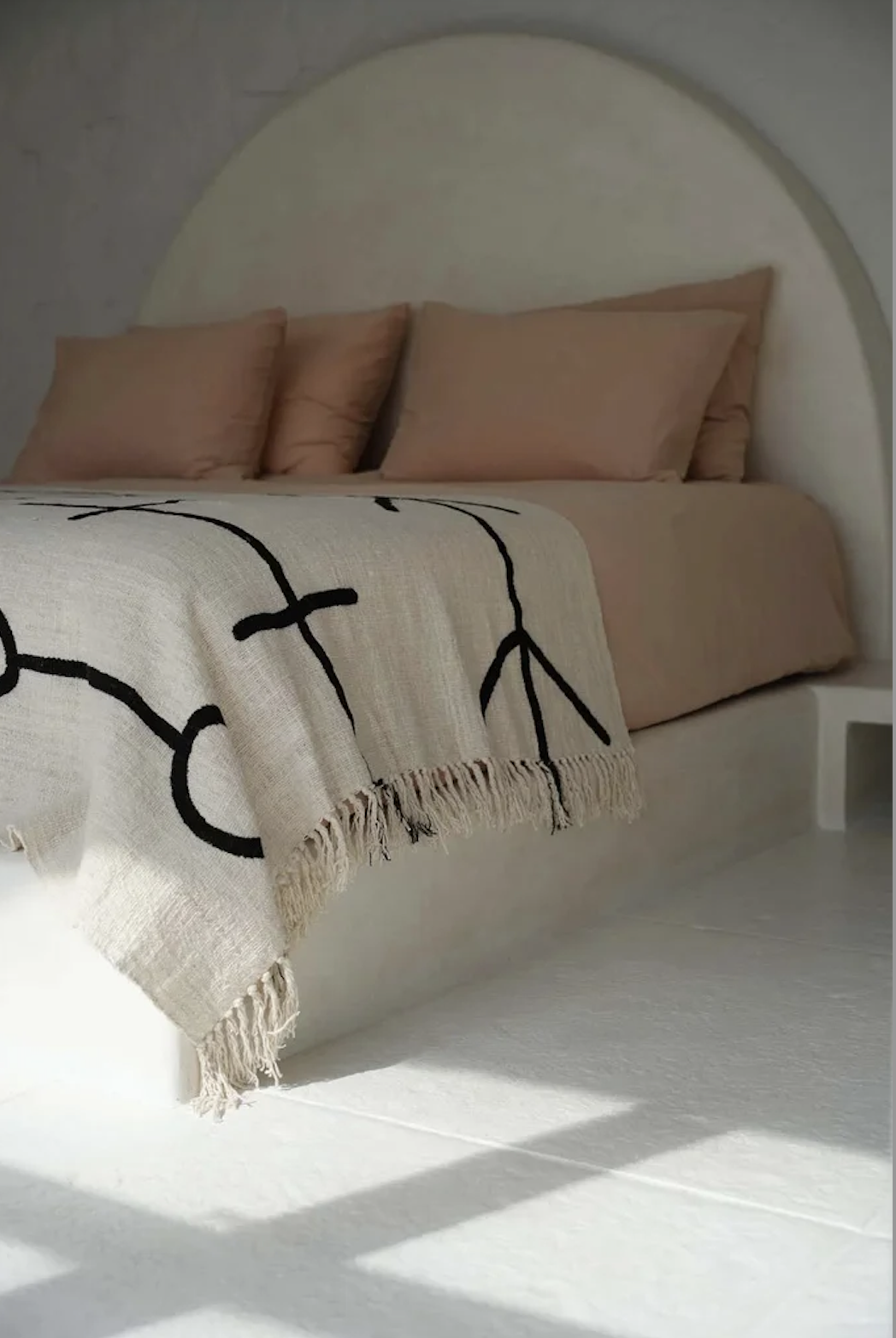 Beige katoenen plaid met zwart lijnmotief op bed – serene winterstijl vol rust en comfort.