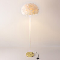 Designad golvlampa Evania med vita fjädrar och fot i guldmässing