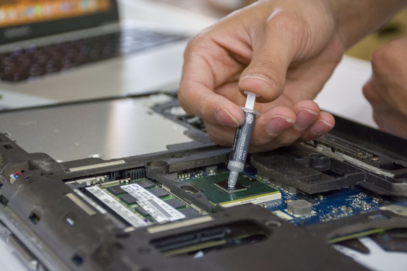 Technicus vervangt de coolpasta op een laptop
