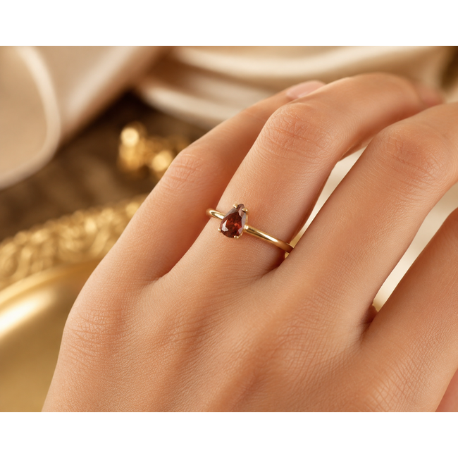 Elegante gouden ring met druppelvormige rode granaat steen