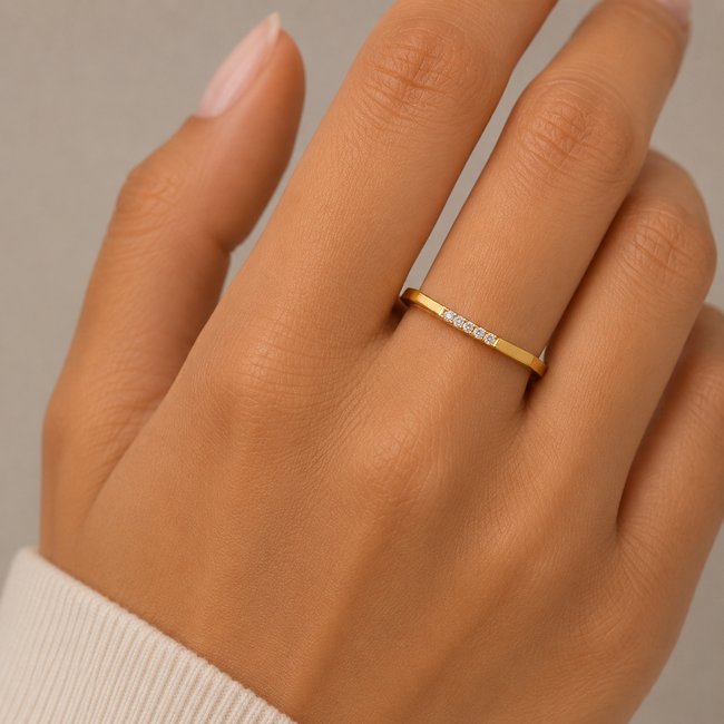 Elegante roodgouden damesring met strakke geometrische vorm en fonkelende zirkonia's