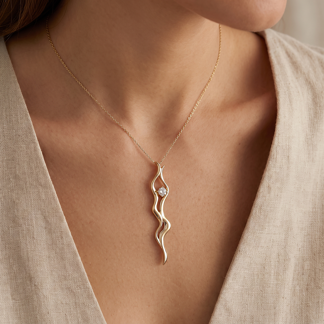 Gouden collier met golvende hanger en zirkonia