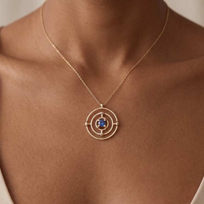 Gouden collier met cirkelhanger en blauwe steen