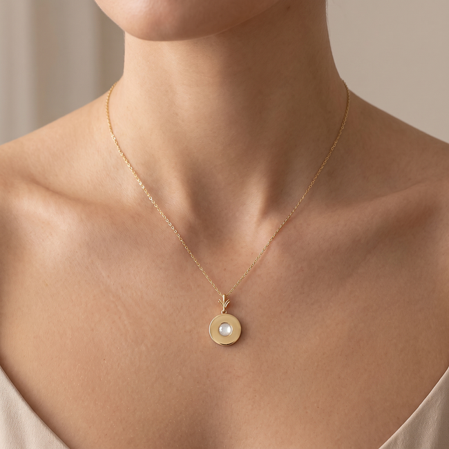 Gouden vollier met ananas hanger en witte steen