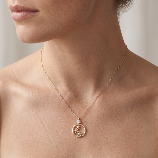 Gouden ketting met ronde hanger en bloemdetails
