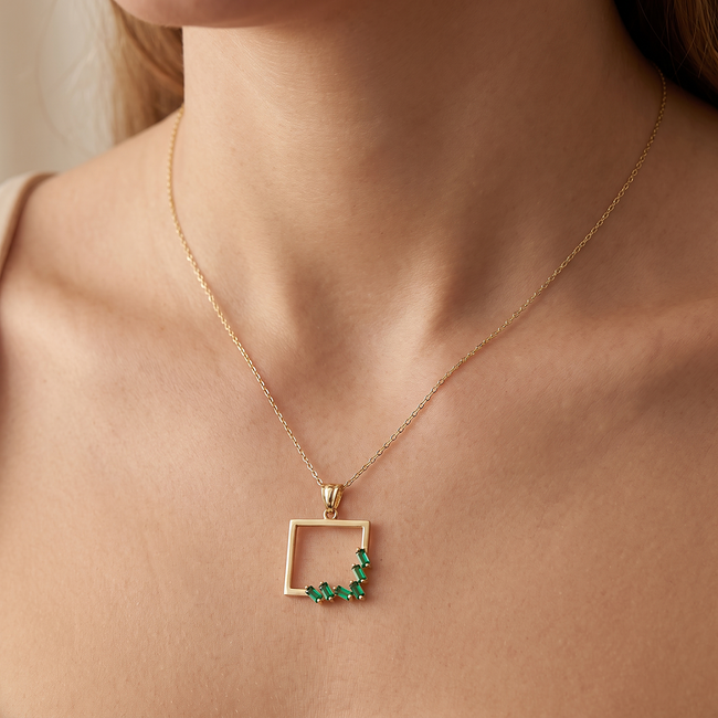 Gouden collier met groene baguette hanger