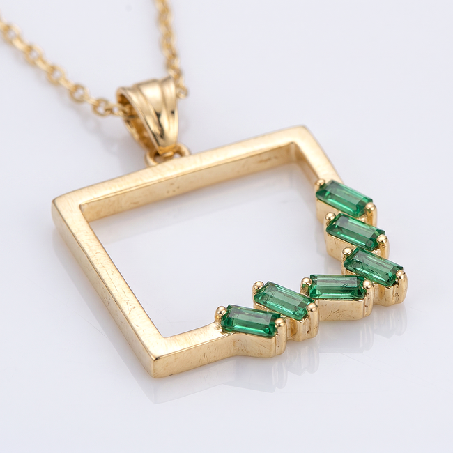 Gouden collier met groene baguette hanger