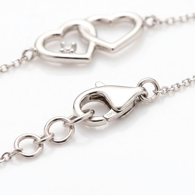 Witgouden armband met dubbele hartjes en diamant