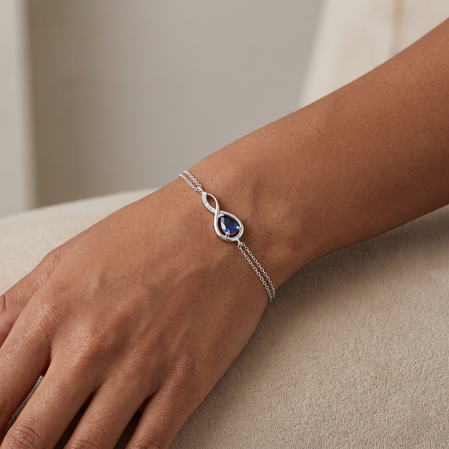Witgouden infinity armband met saffier en diamant