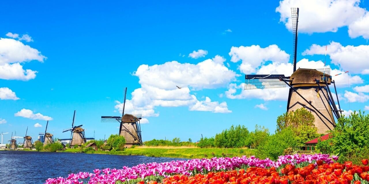 Schilderij Kleurrijk lentelandschap met beroemde molens | 140 x 70 cm glasschilderij Schilderij Kleurrijk lentelandschap met beroemde molens | 140 x 70 cm glasschilderij