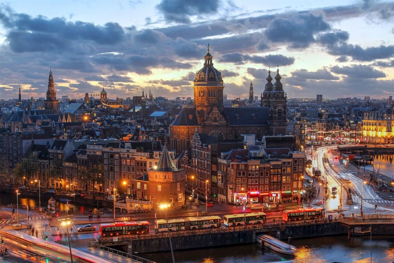Keel pakket Syndicaat Luchtfoto van Amsterdam in de avond • 120 x 80 cm • Glazenschilderijen.nl
