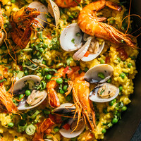 Paella met garnalen, mosselen en doperwten recept