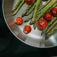 Zielone szparagi z pomidorkami cherry na gałązce