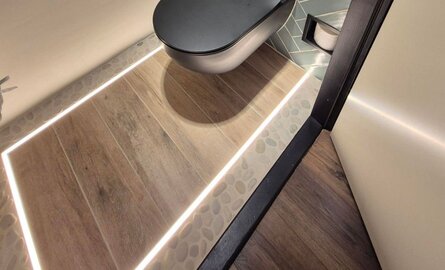 Toiletvloer en wand voorzien van LED profielen en LED strips
