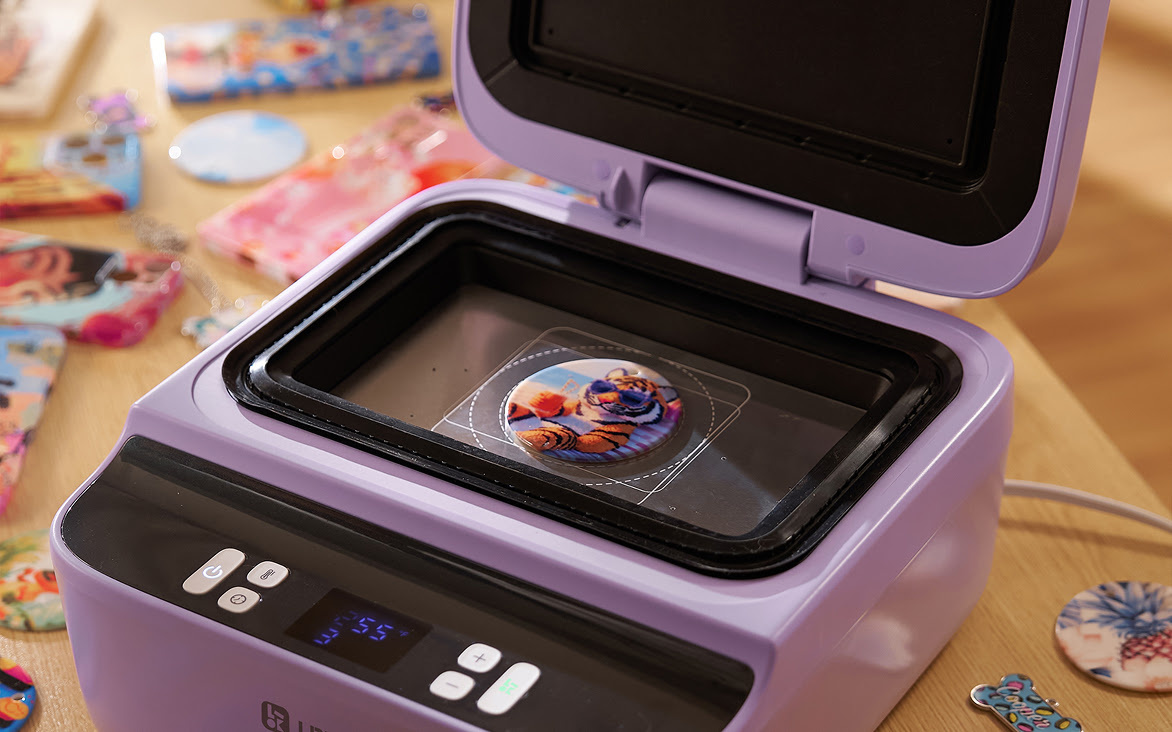 LOKLiK Phone Case Heat Press in Lavender Purple with the lid open. Inside is a button with a sublimated design of a tiger wearing sunglasses.