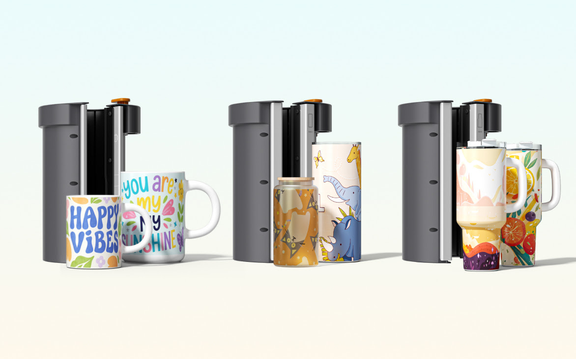 Three different interchangeable sublimation heat plate modules standing behind custom printed ceramic mugs, glass cans, and massive 1.2-litre travel tumblers with handles.